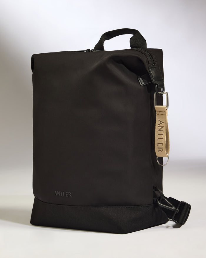 a black bag with a tan strap