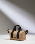 a tan bag with black straps