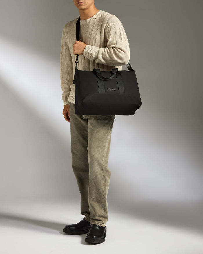 a man holding a black bag