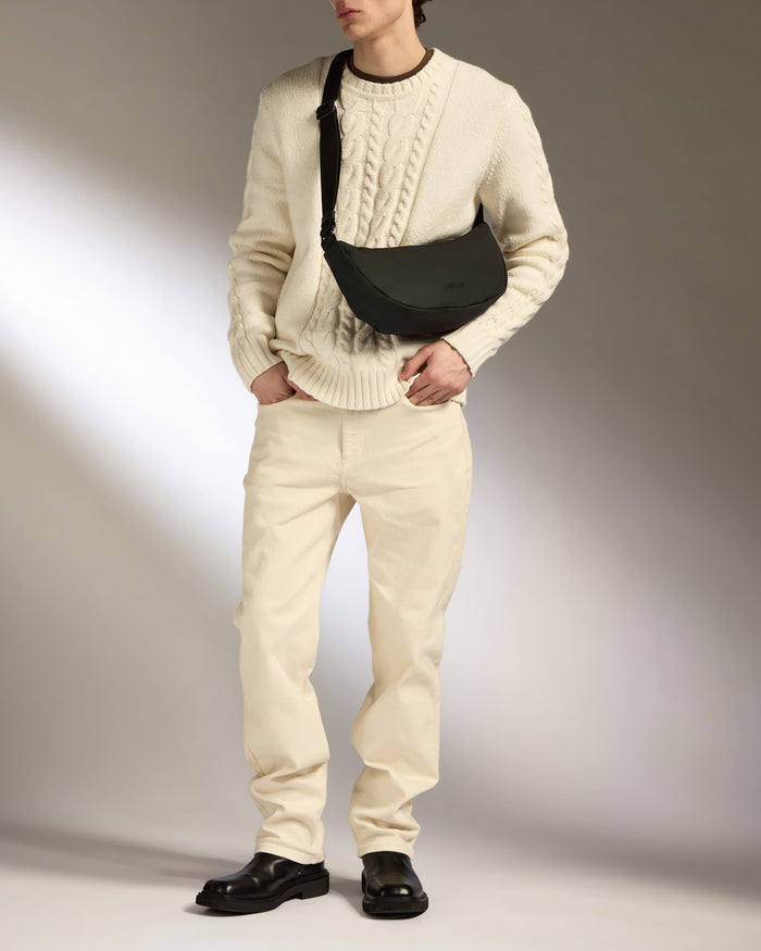 a man in a white sweater and white pants