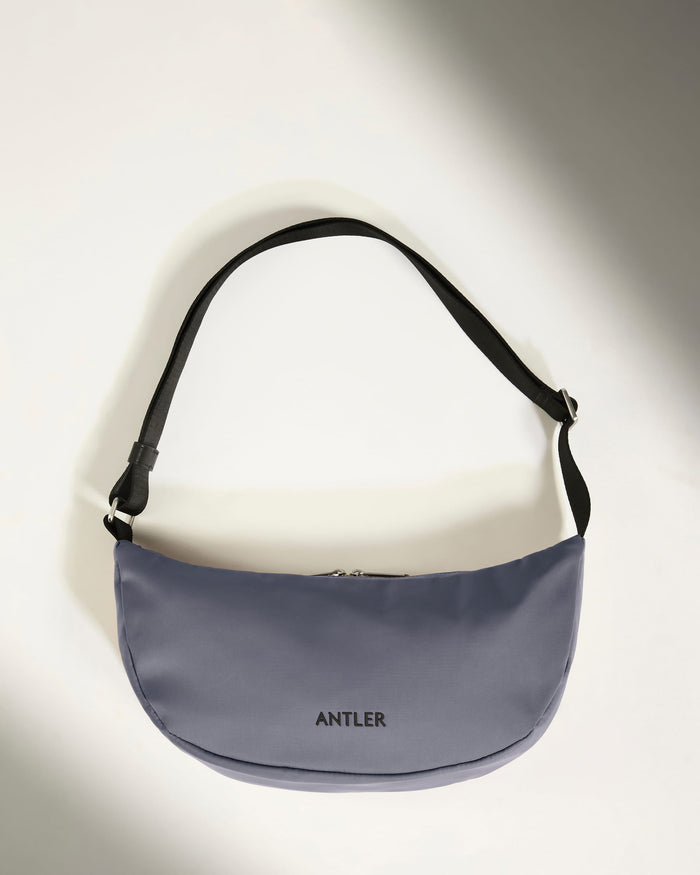 a grey bag with a black strap
