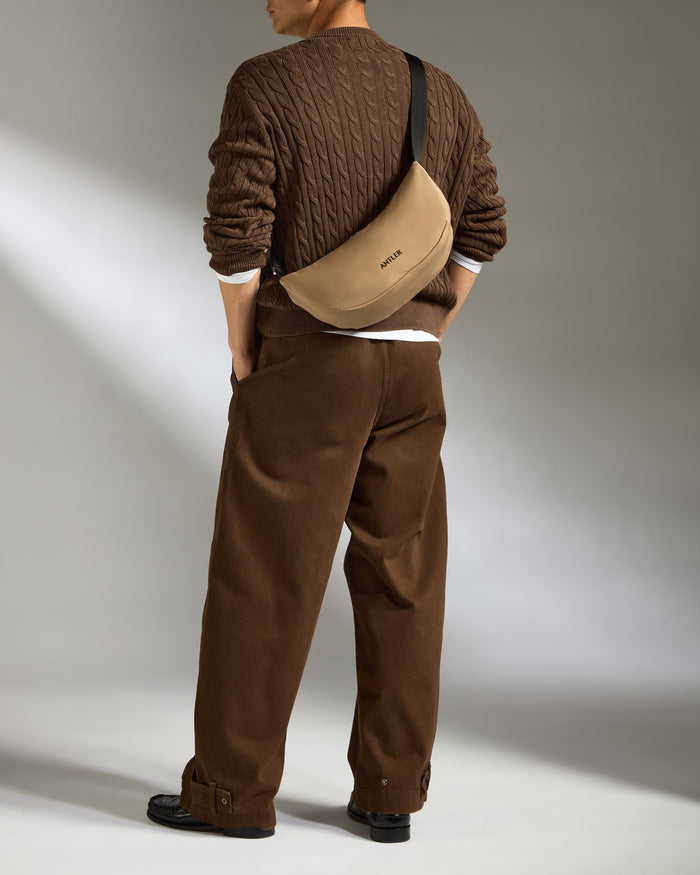 a man wearing brown pants and a brown sweater