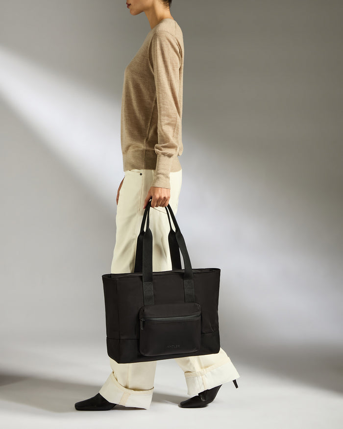 a woman holding a black bag