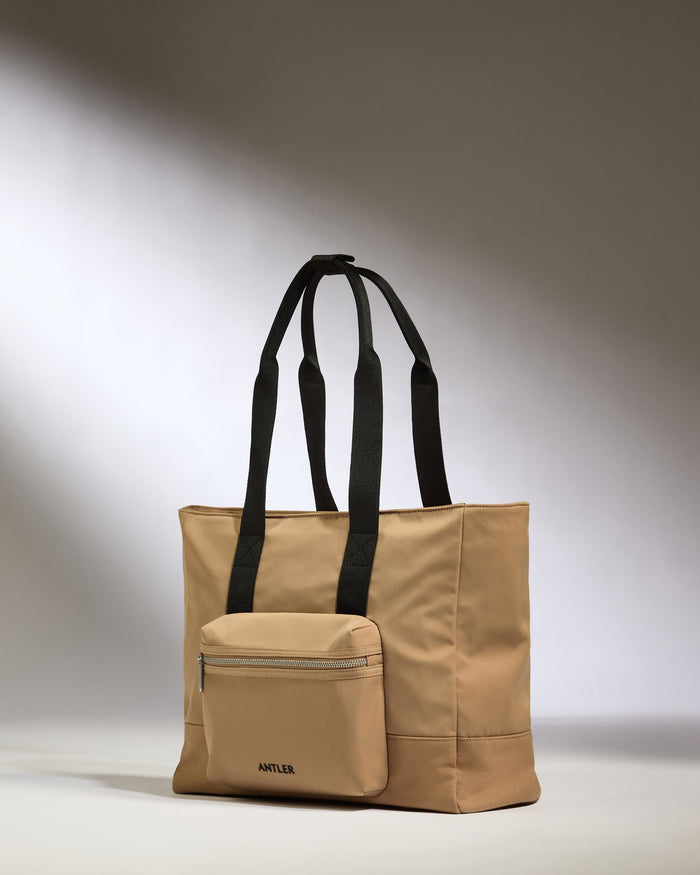 a tan bag with black straps