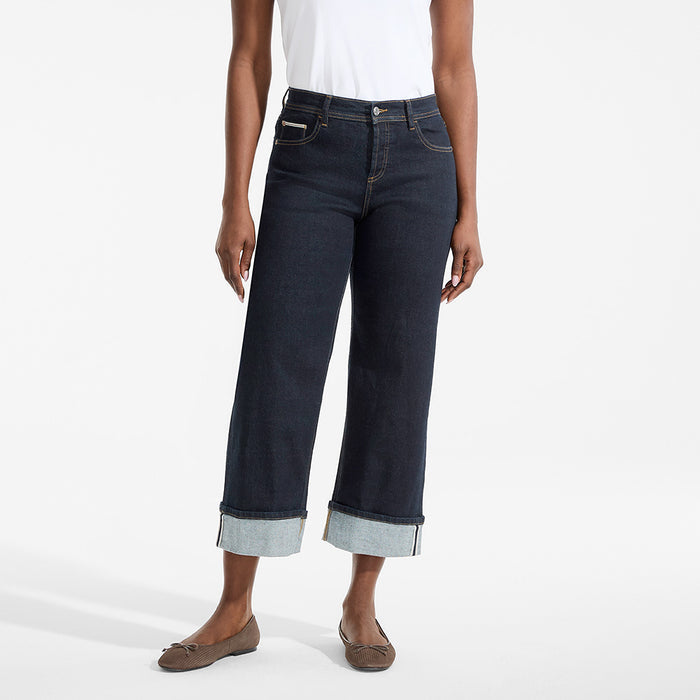 Person wearing dark blue jeans with a white background