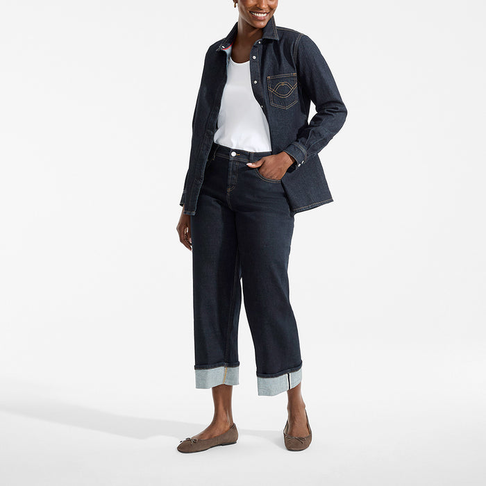 Person wearing a denim jacket and jeans on a white background