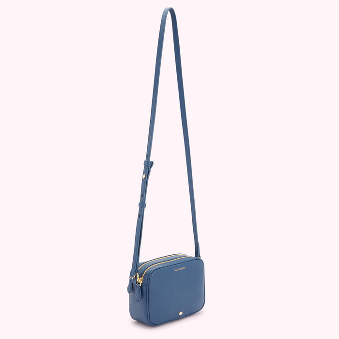 Blue leather crossbody bag with gold hardware and long strap.