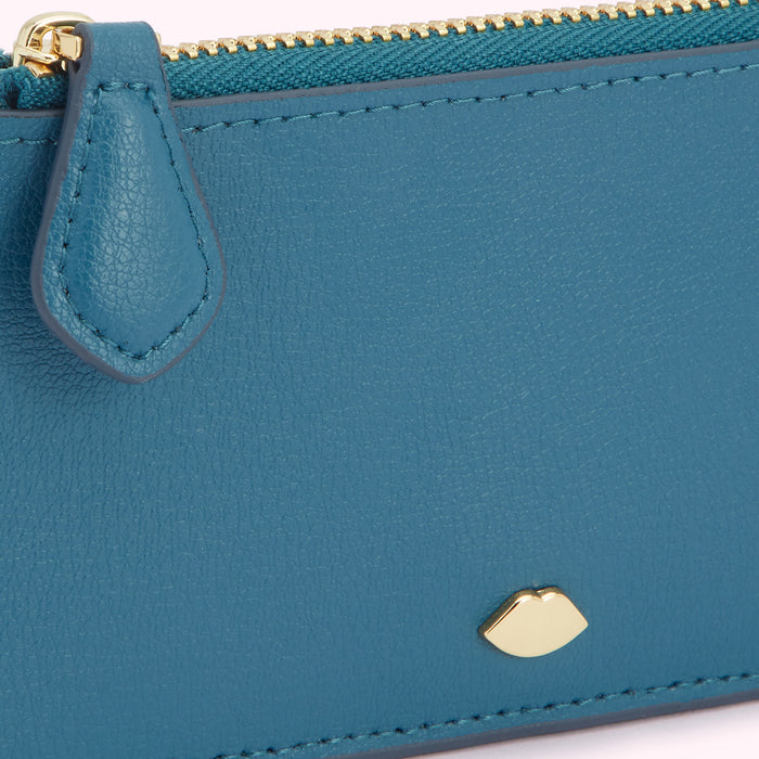 Close-up of a teal leather zippered wallet with gold-coloured zipper and lip-shaped logo.
