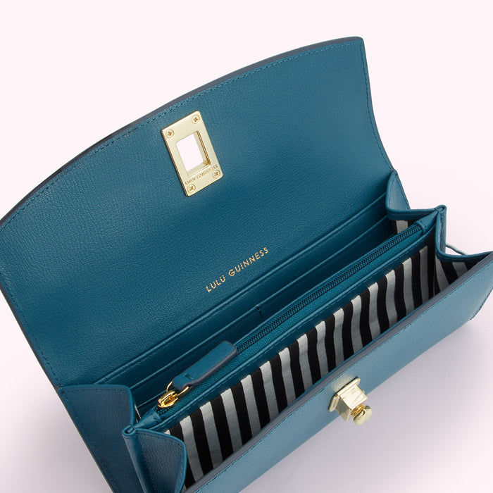 Open teal leather Lulu Guinness wallet with gold-tone hardware and black and white striped interior.