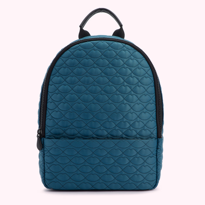 Teal quilted backpack with black zippers and straps; the quilting pattern is a repeating lip design.