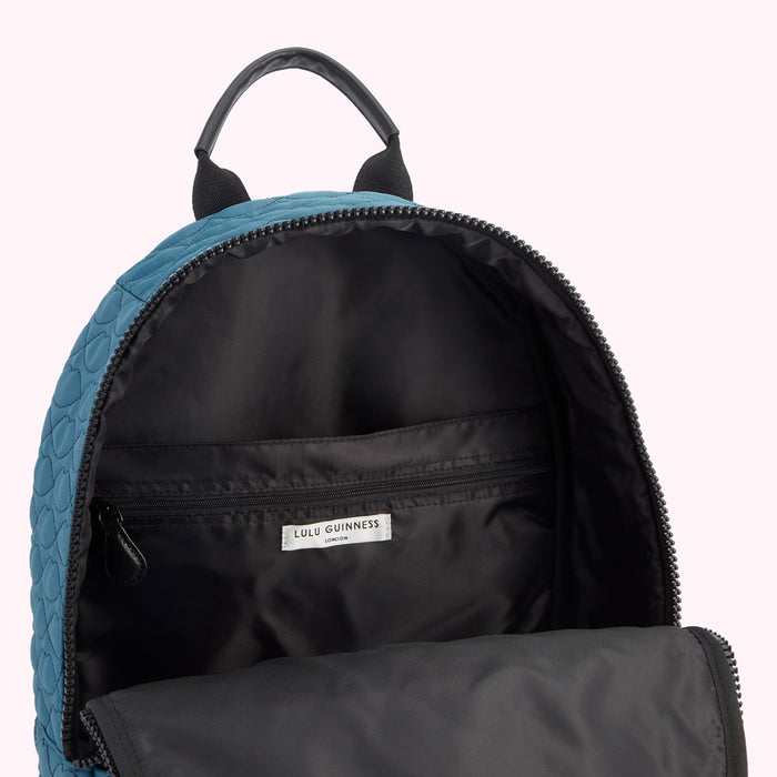 Teal Lulu Guinness London quilted backpack with black interior, open to show details.