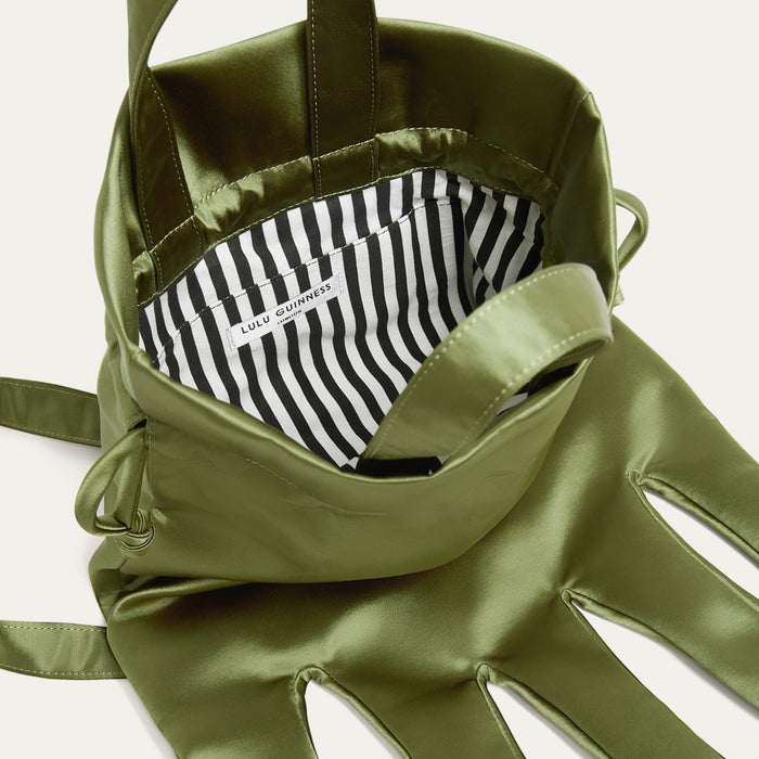 Green satin hand-shaped backpack with striped lining on a white background