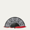 Black handheld fan with white floral lace patterns and red accents on a light gray background