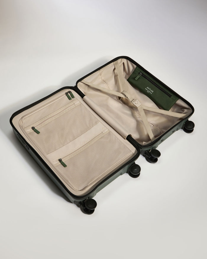 a suitcase with wheels and a green bag