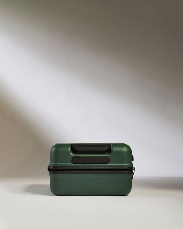 a green suitcase on a white surface