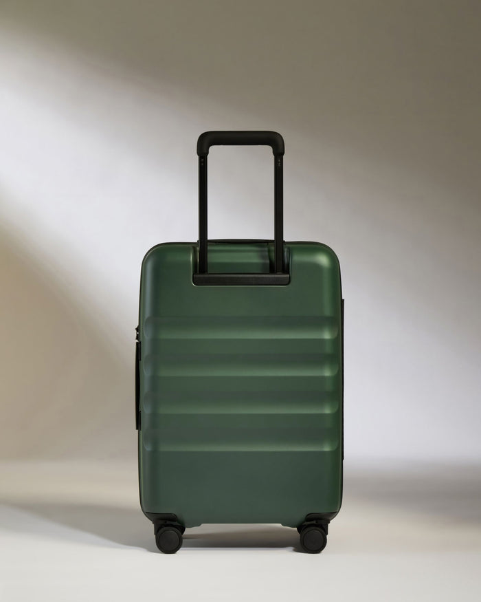 a green suitcase with black handles