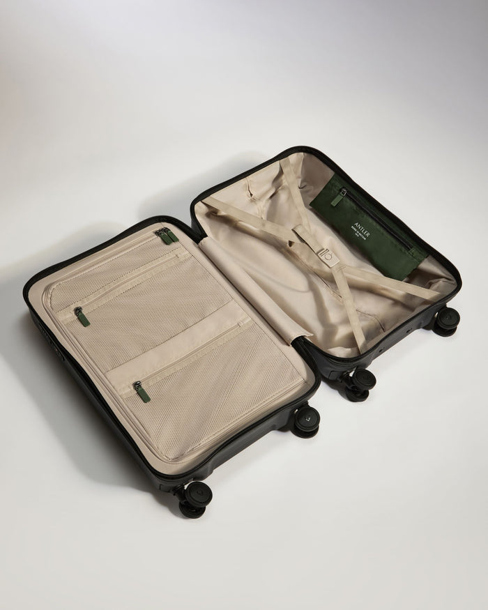a suitcase with wheels and a green and black bag