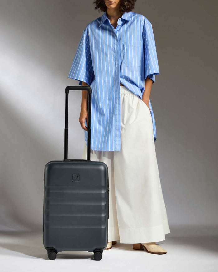 a woman standing next to a suitcase