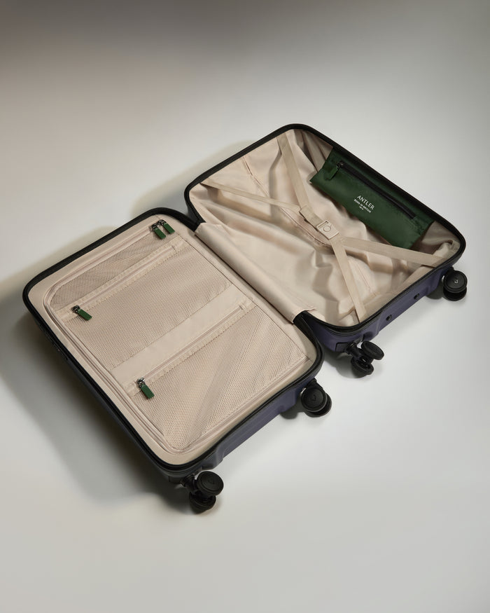 a suitcase with wheels and a green purse