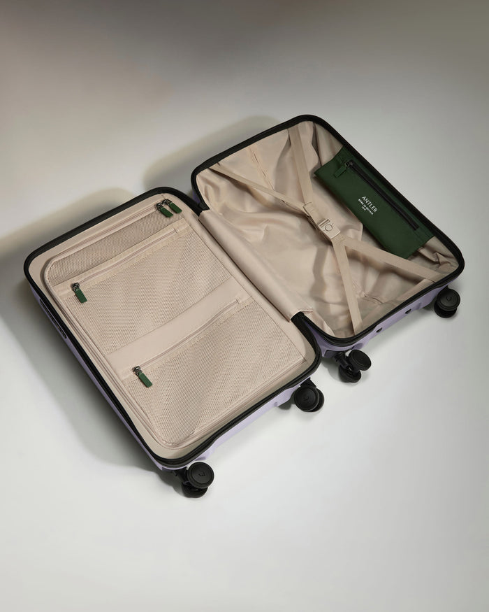 a suitcase with wheels and a green wallet