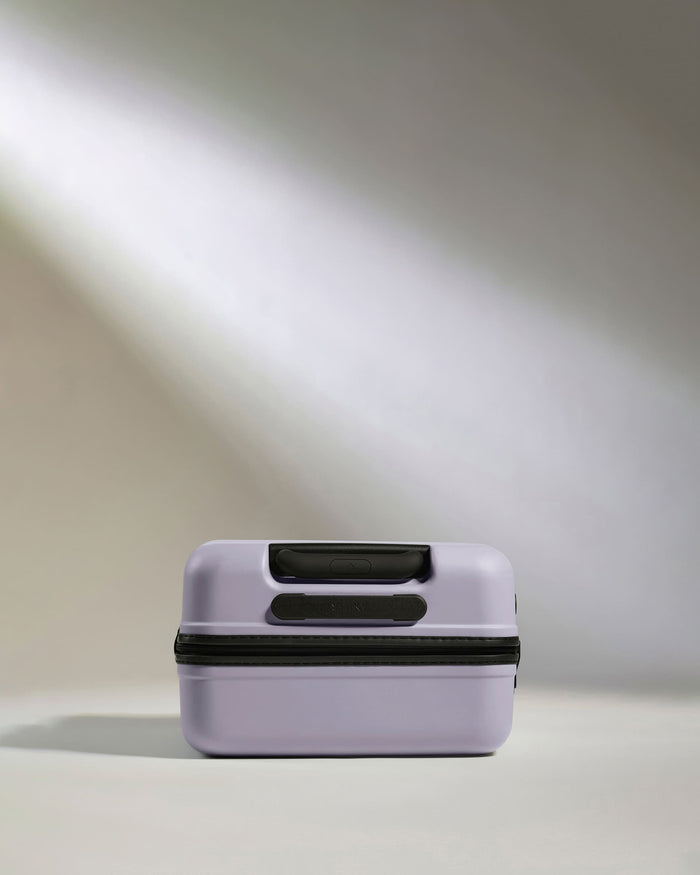 a small purple suitcase with black straps