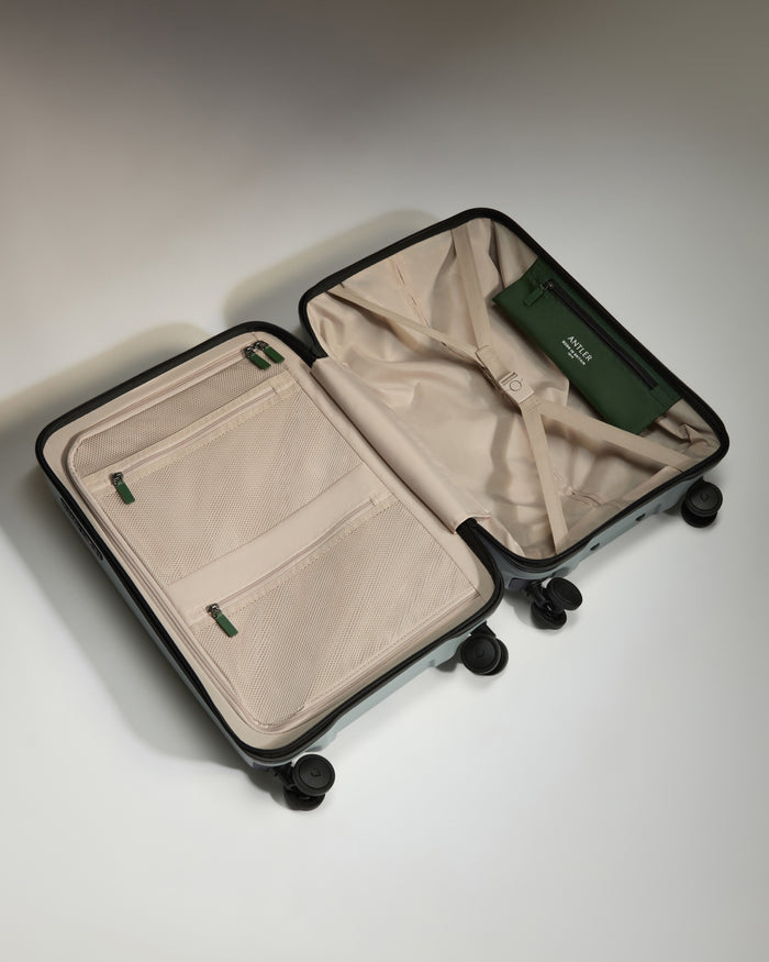 a suitcase with wheels and a green wallet inside