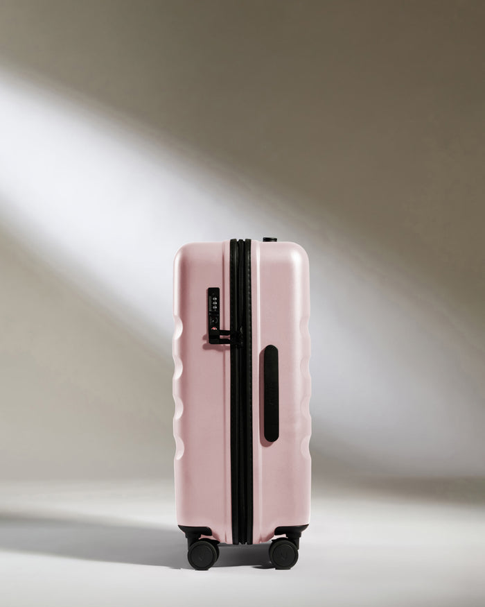 a pink suitcase with wheels