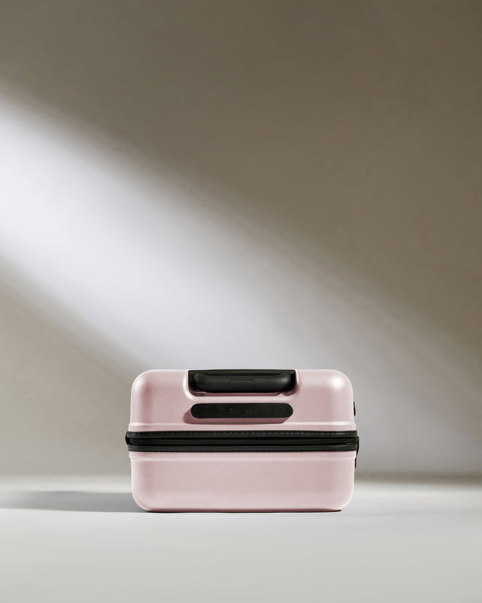 a pink suitcase with black handles
