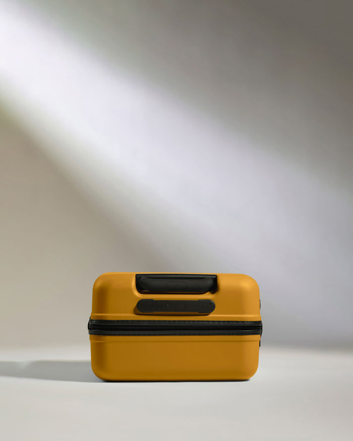 a yellow suitcase with black straps