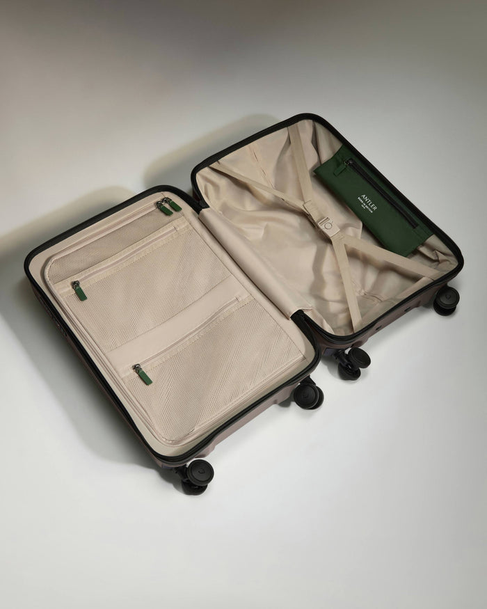 a suitcase with wheels and a green wallet