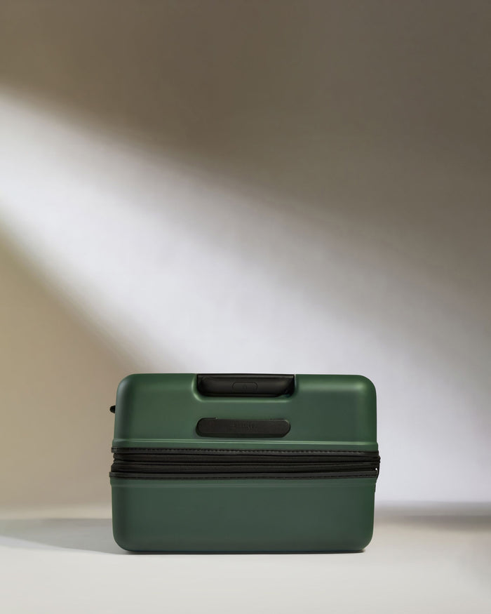 a green suitcase with a black handle