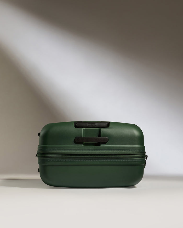 a green suitcase with a light shining on it