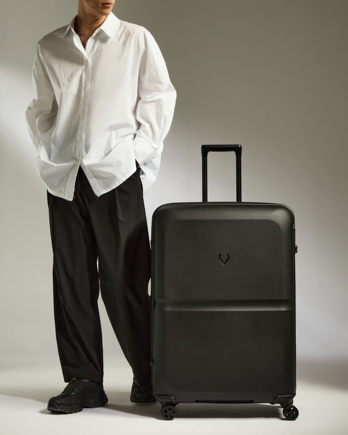 a man standing next to a suitcase