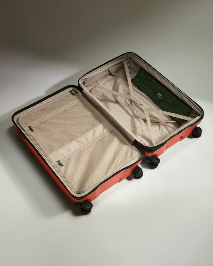 a suitcase with wheels and a green bag