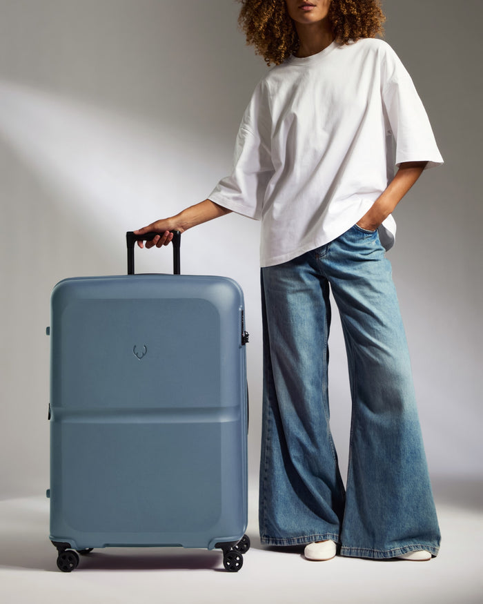 a woman standing with a suitcase