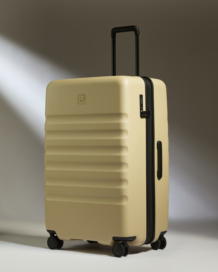 a tan suitcase with black wheels