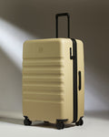 a tan suitcase with black wheels