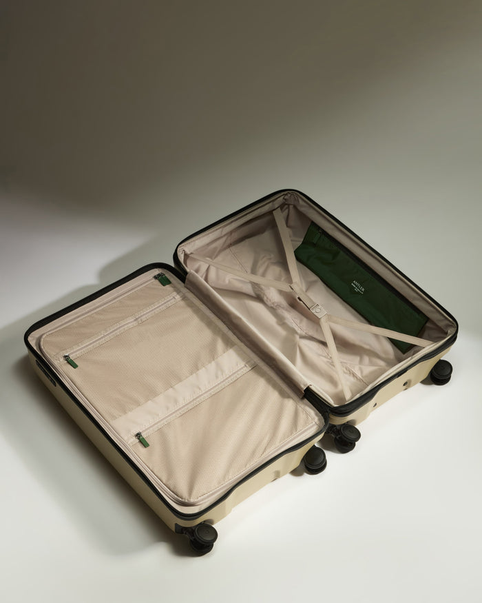 a suitcase with wheels and a green bag