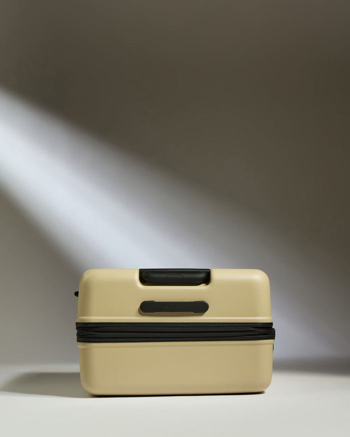 a tan suitcase with a black handle