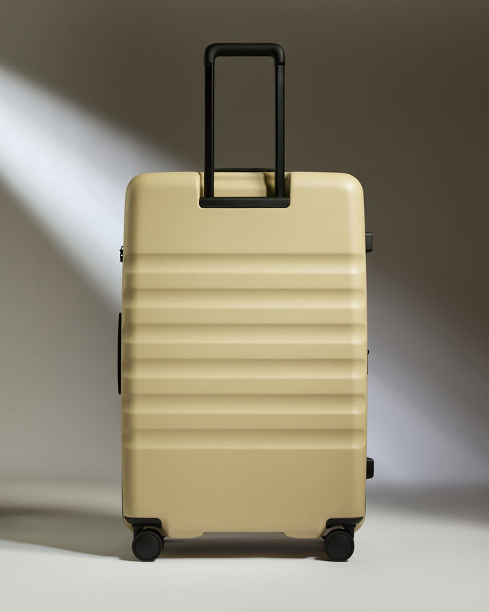 a tan suitcase with black handles
