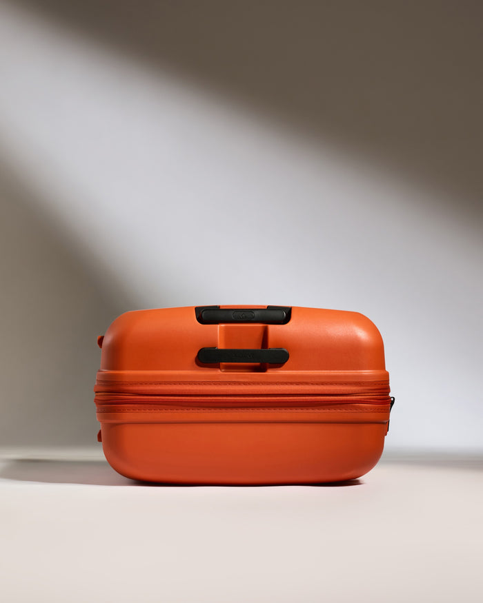 an orange suitcase with black handles