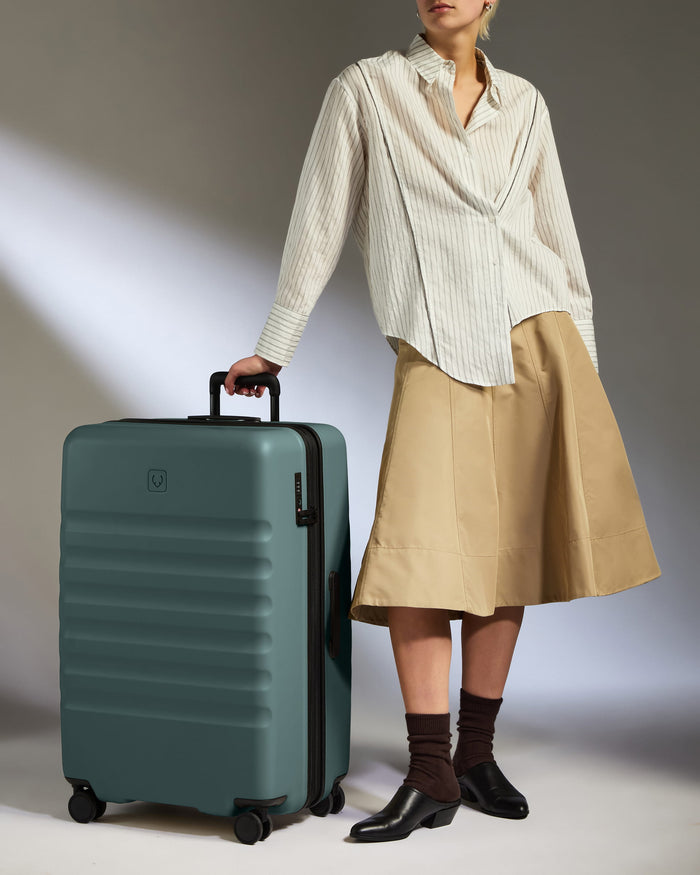 a woman standing next to a suitcase