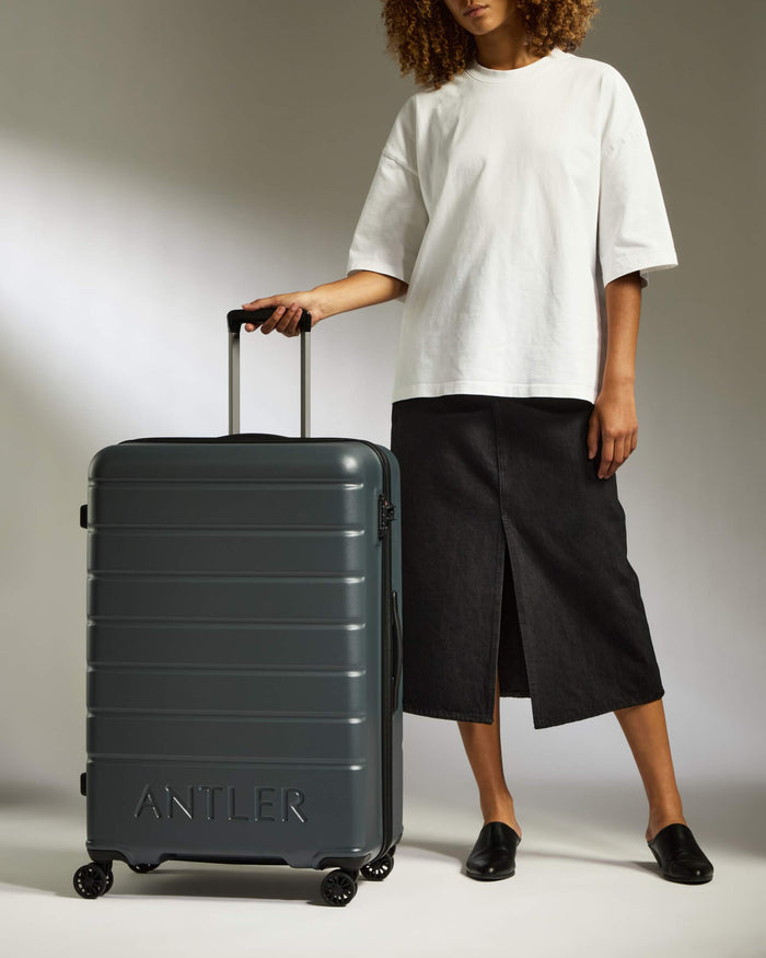 a woman standing next to a suitcase