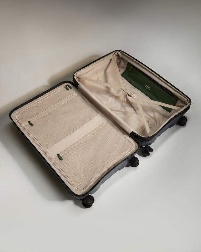 a suitcase with wheels and a green bag