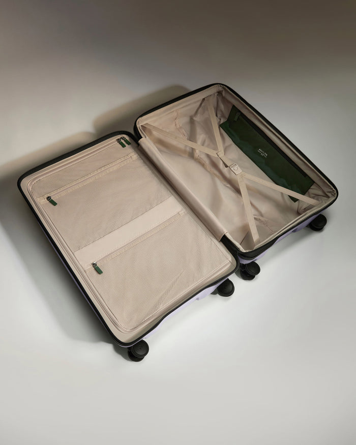 a suitcase with wheels and a green bag