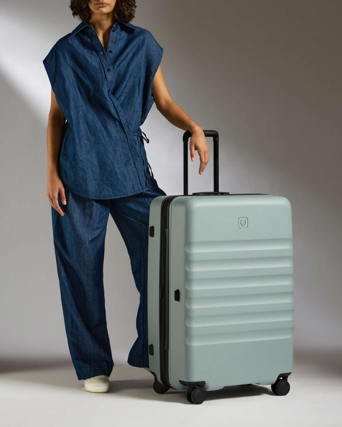 a woman standing next to a suitcase
