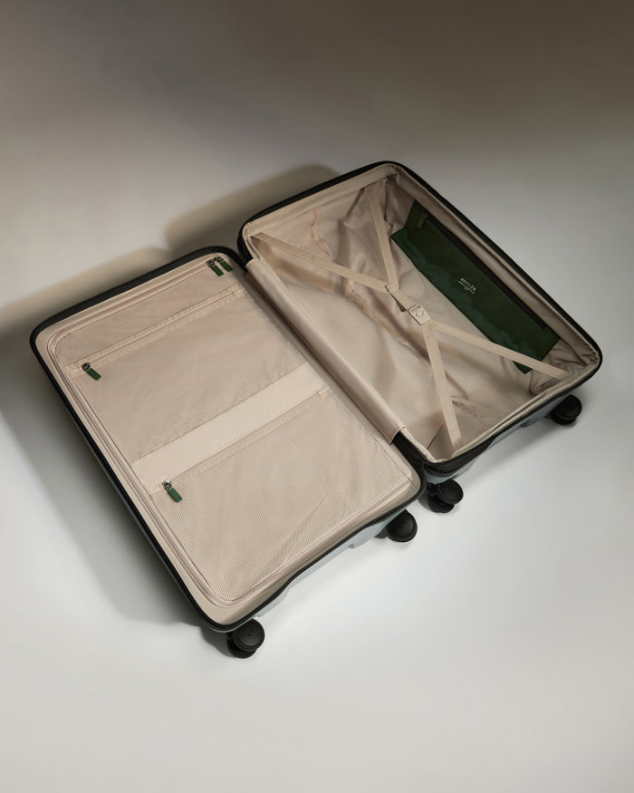a suitcase with wheels and a green bag