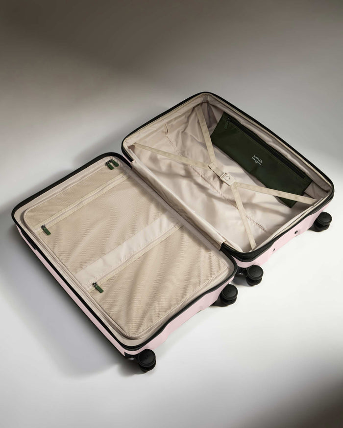 a suitcase with wheels and a green bag