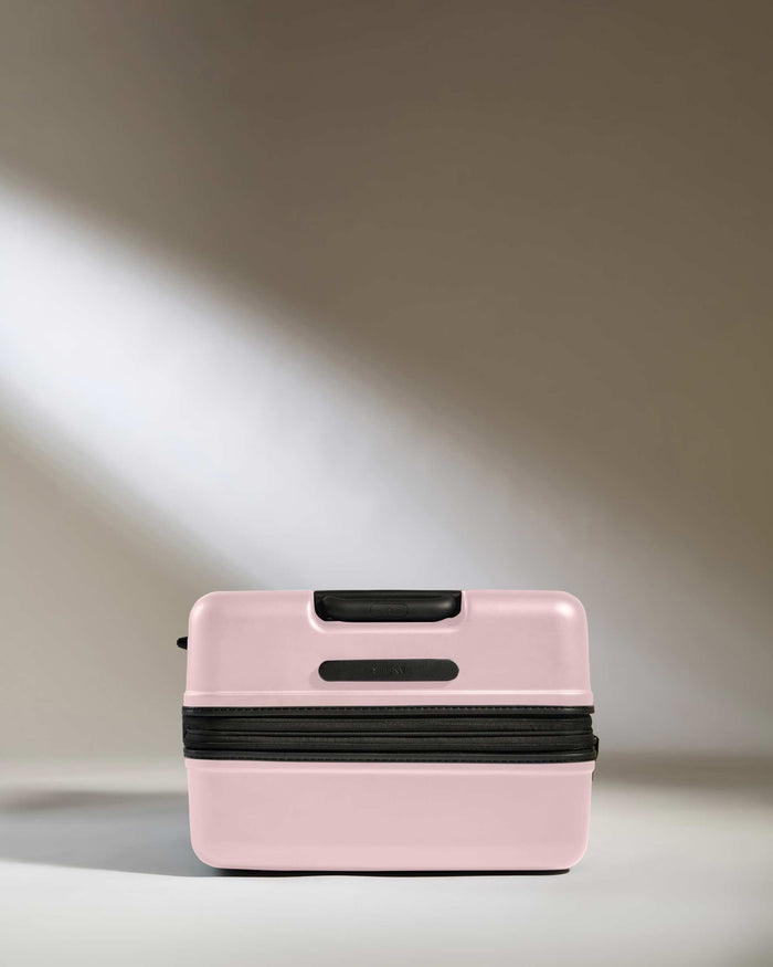a pink suitcase with a light shining on it