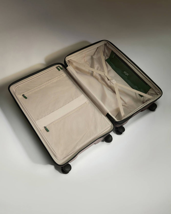 a suitcase with wheels and a green bag
